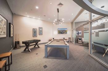 A room with a pool table and a tv mounted on the wall.